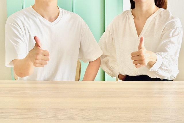 グーサインをする男女二人の写真